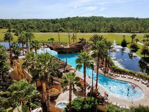 Un resort con varias piscinas, una atracción acuática con temática de barco pirata y abundante vegetación.