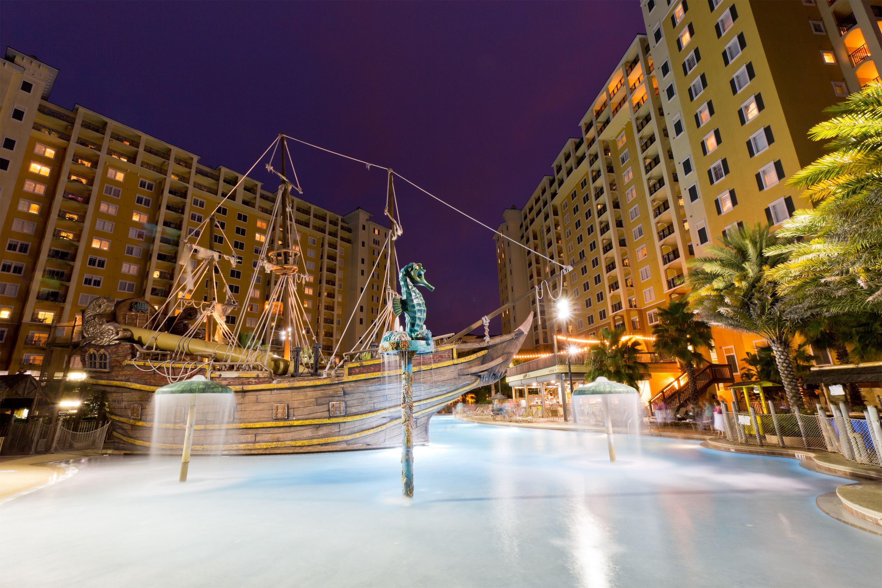 Une grande fontaine intérieure, avec une sculpture de bateau au centre, entourée de grands immeubles d’habitation.