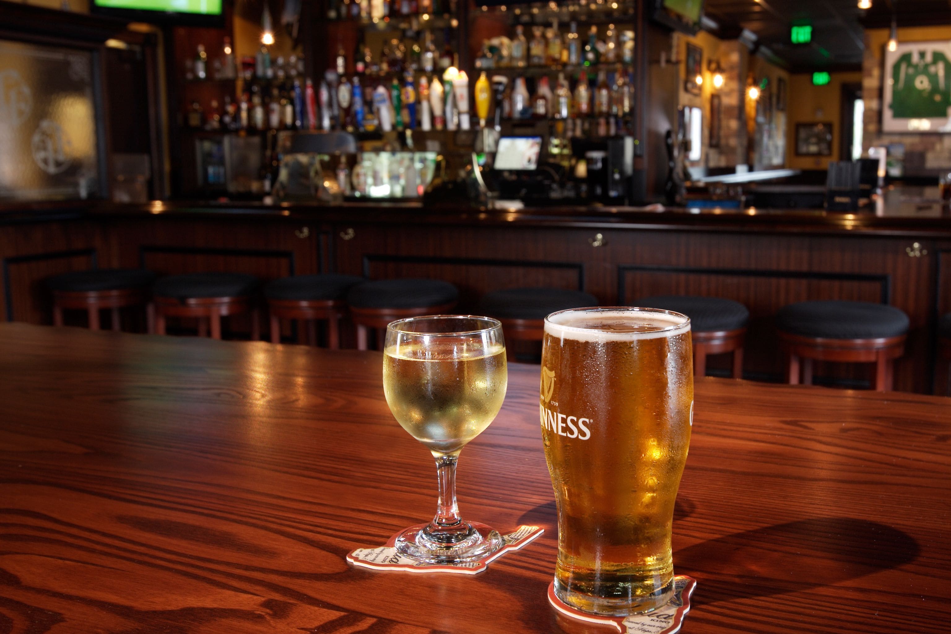 A bar with two glasses of beer on a wooden table.
