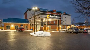 A Comfort Inn hotel with a parking lot, snow on the ground, and cars parked.