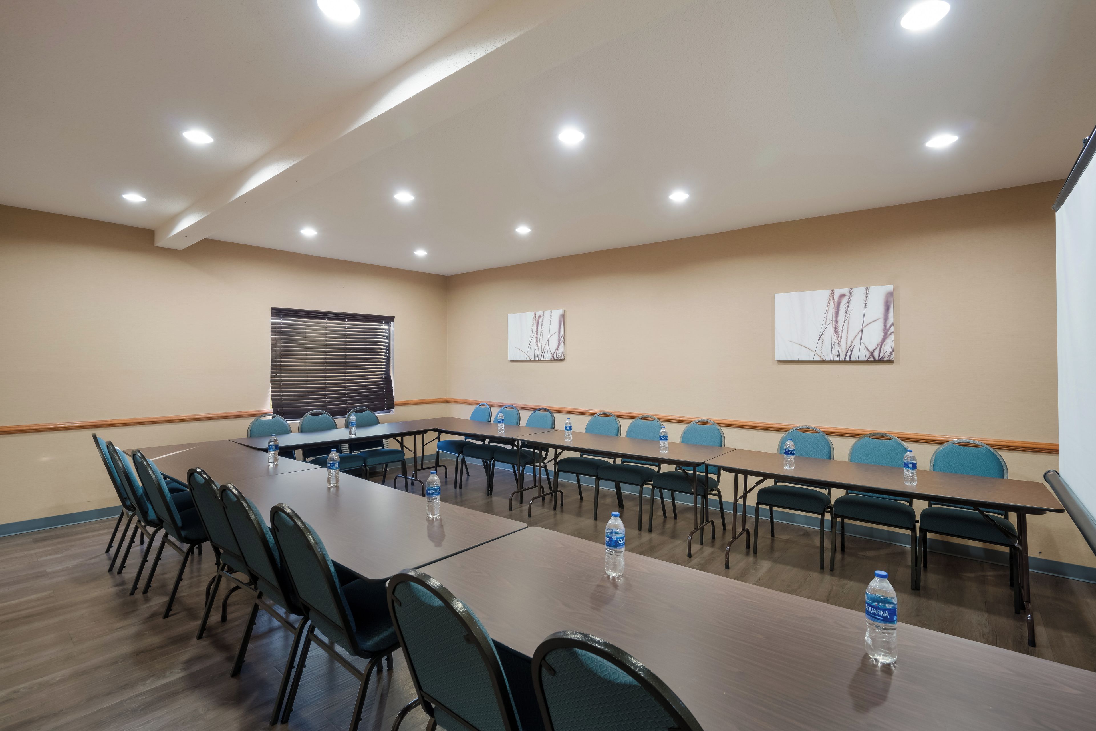 A conference room with a long table, chairs, and water bottles.