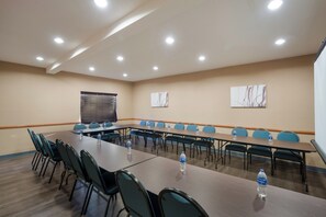 A conference room with a long table, chairs, and water bottles. - Red Roof Inn & Suites Carrollton, GA–West Georgia (Carrollton)