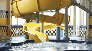 A water slide structure in a pool area with multiple levels and a lifeguard stand. - Deerfoot Inn & Casino (Calgary)