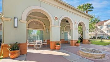 A building with a covered patio area featuring outdoor seating and planters.