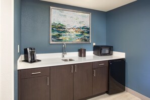 A compact kitchen with a coffee maker, microwave, and dishwasher. - Holiday Inn Hotel & Suites Tallahassee Conference Ctr N by IHG (Tallahassee)