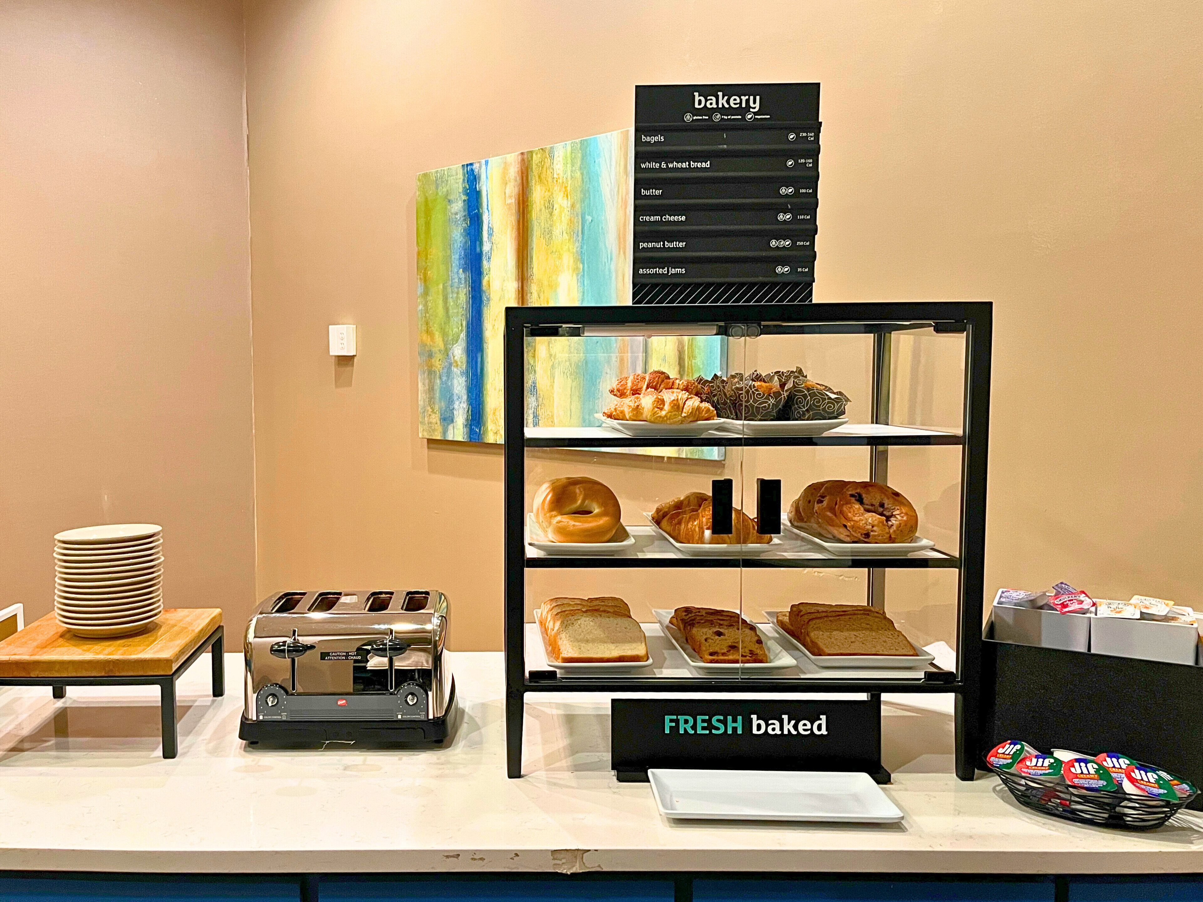 A bakery display with various baked goods and a sign indicating 'FRESH baked' items.