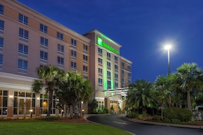 A Holiday Inn & Suites hotel with a modern facade, large windows, and a well-lit entrance. - Holiday Inn Hotel & Suites Tallahassee Conference Ctr N by IHG (Tallahassee)