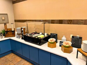 A breakfast bar with various food options, including fruit and yogurt, and a sign indicating hot foods available. - Holiday Inn Hotel & Suites Tallahassee Conference Ctr N by IHG (Tallahassee)