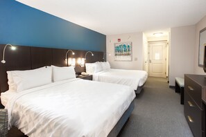 A hotel room with two beds, a desk, a chair, a dresser, and a painting on the wall. - Holiday Inn Hotel & Suites Tallahassee Conference Ctr N by IHG (Tallahassee)