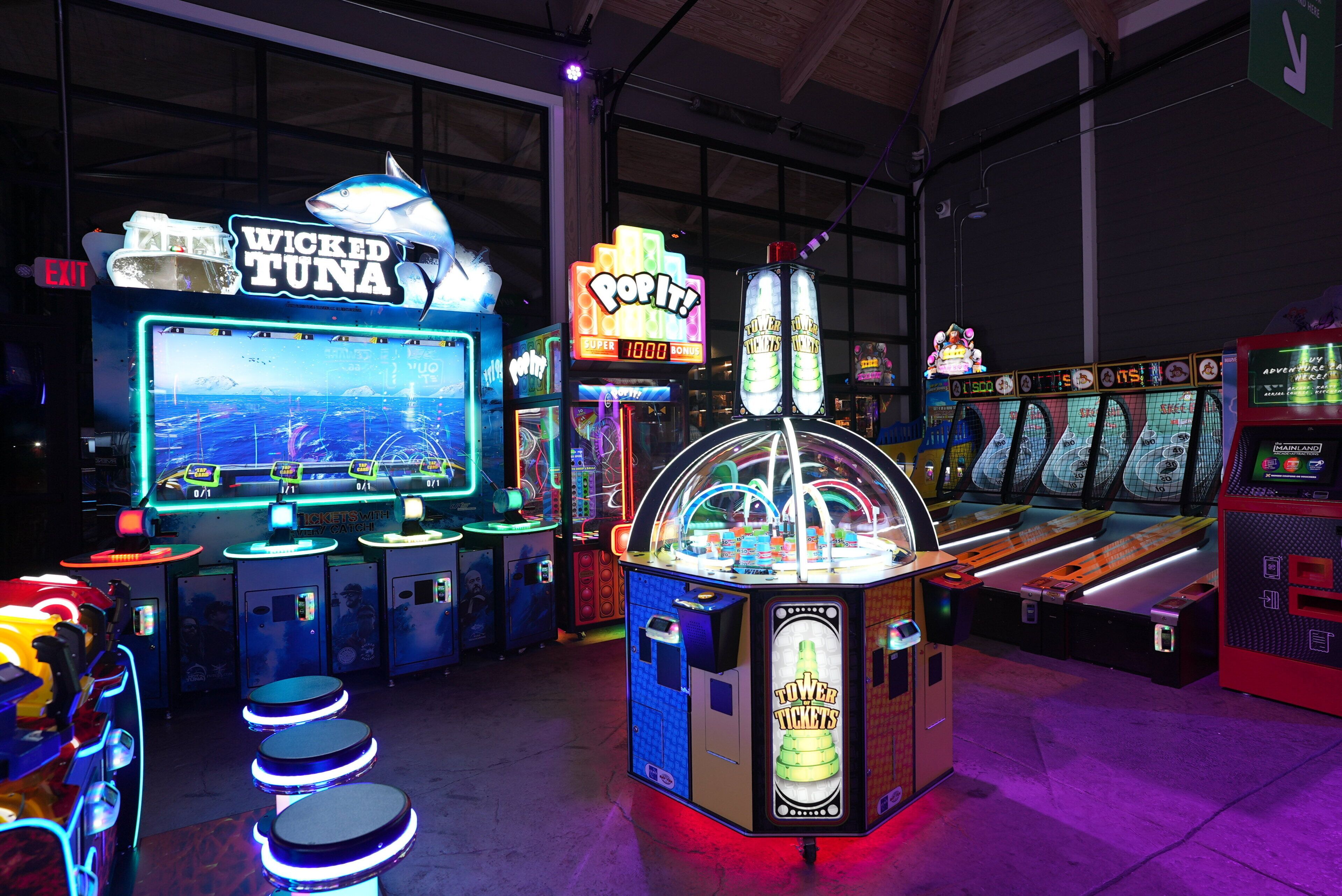 Une salle d’arcade proposant divers jeux, notamment un jeu intitulé « Wicked Tuna » et un jeu intitulé « Pop It! ».
