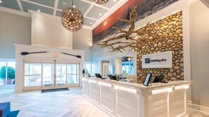 A reception area with a stone wall, a Holiday Inn sign, and a reception desk. - Holiday Inn Manahawkin/Long Beach Island by IHG (Manahawkin)