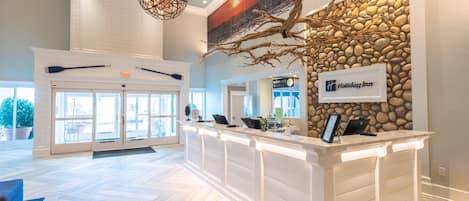 Ein Empfangsbereich mit Steinwand, Holiday Inn Schild und einer Rezeption.