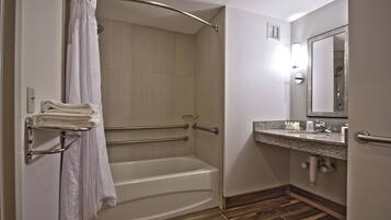 A bathroom with a shower, a bathtub, a towel rack, a sink, and a mirror.