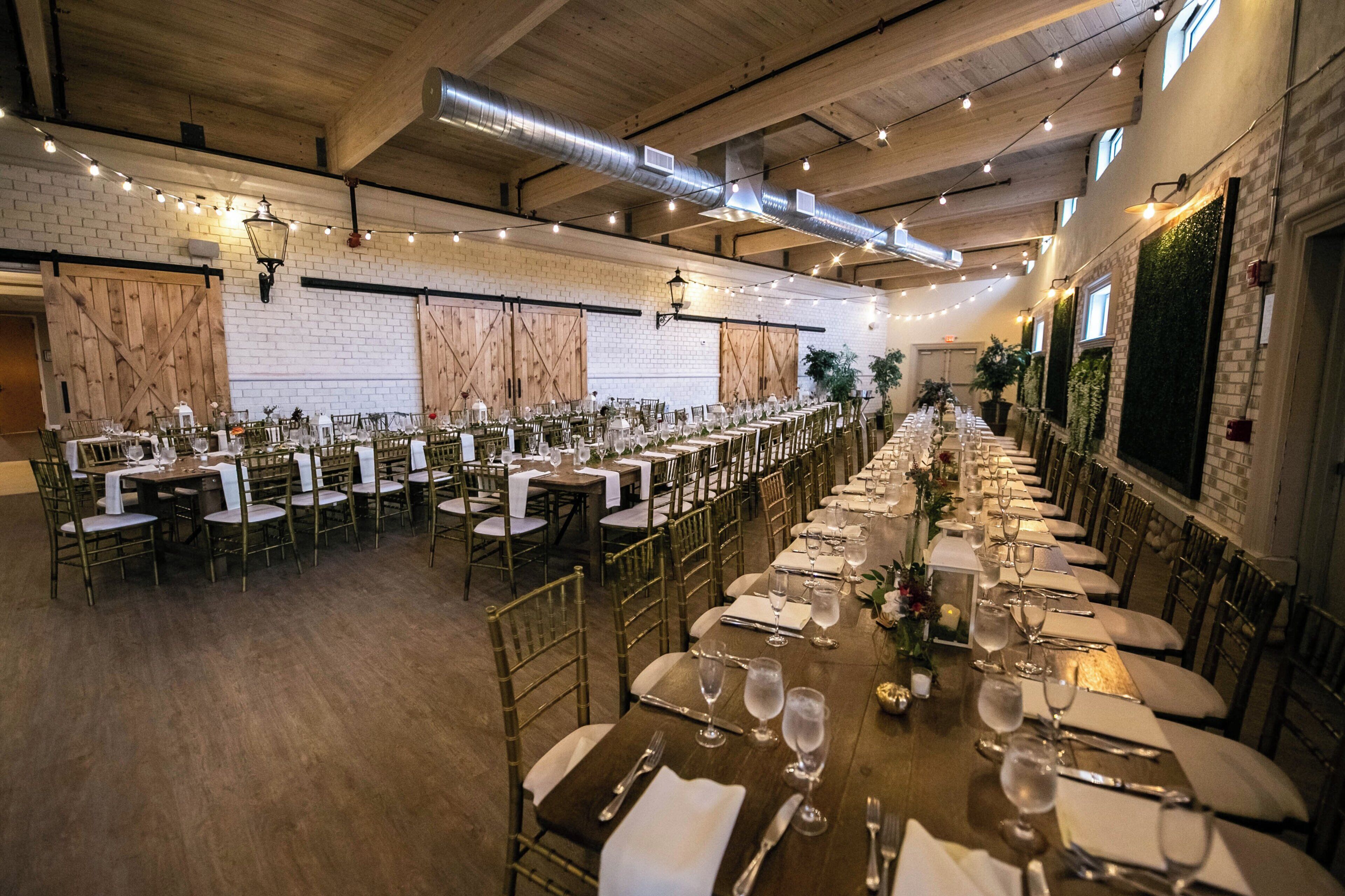 Una larga mesa de banquete dispuesta para un evento formal, con múltiples sillas y cubiertos.