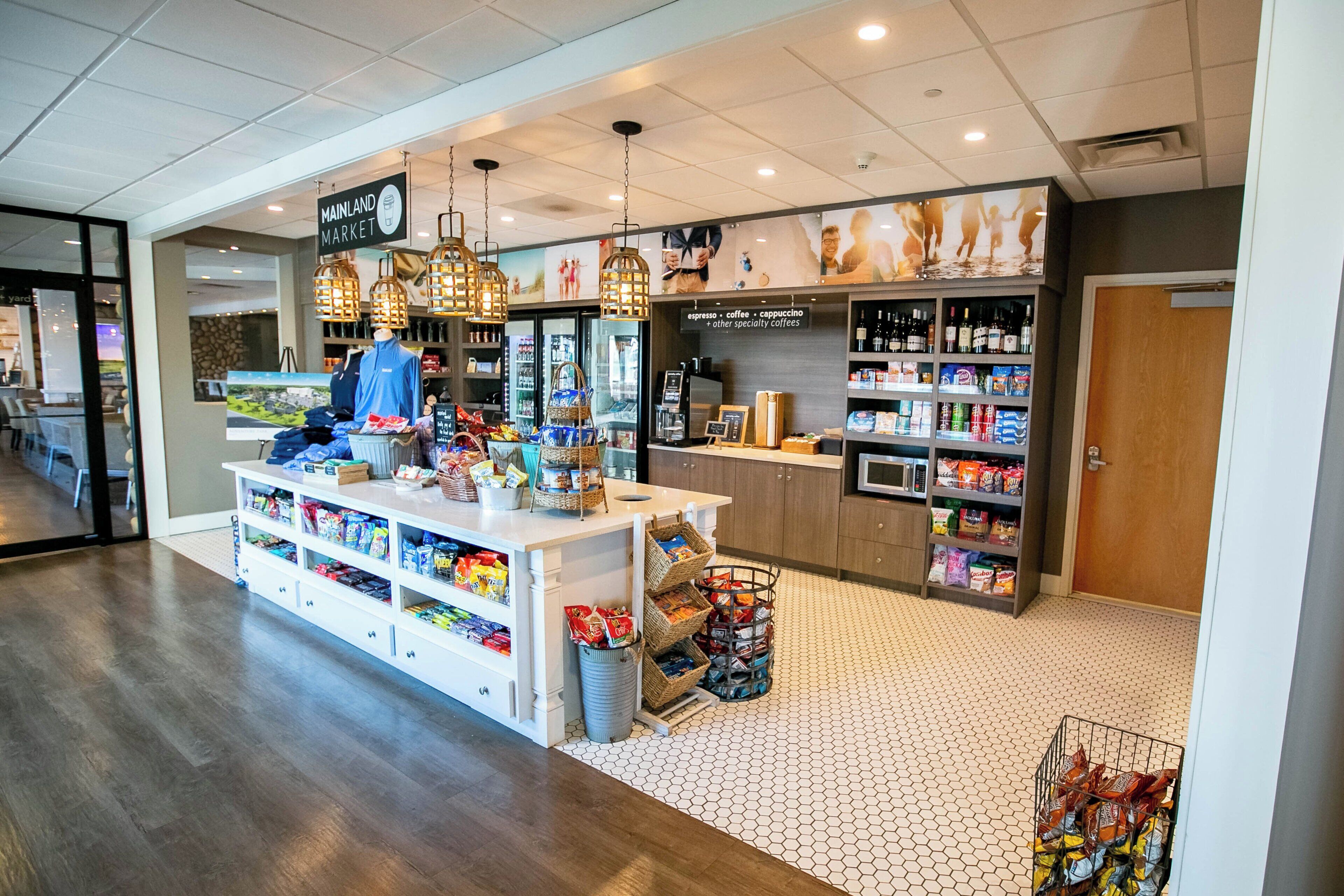 L’intérieur d’un café, avec un comptoir, des étagères remplies de collations et des lampes suspendues.