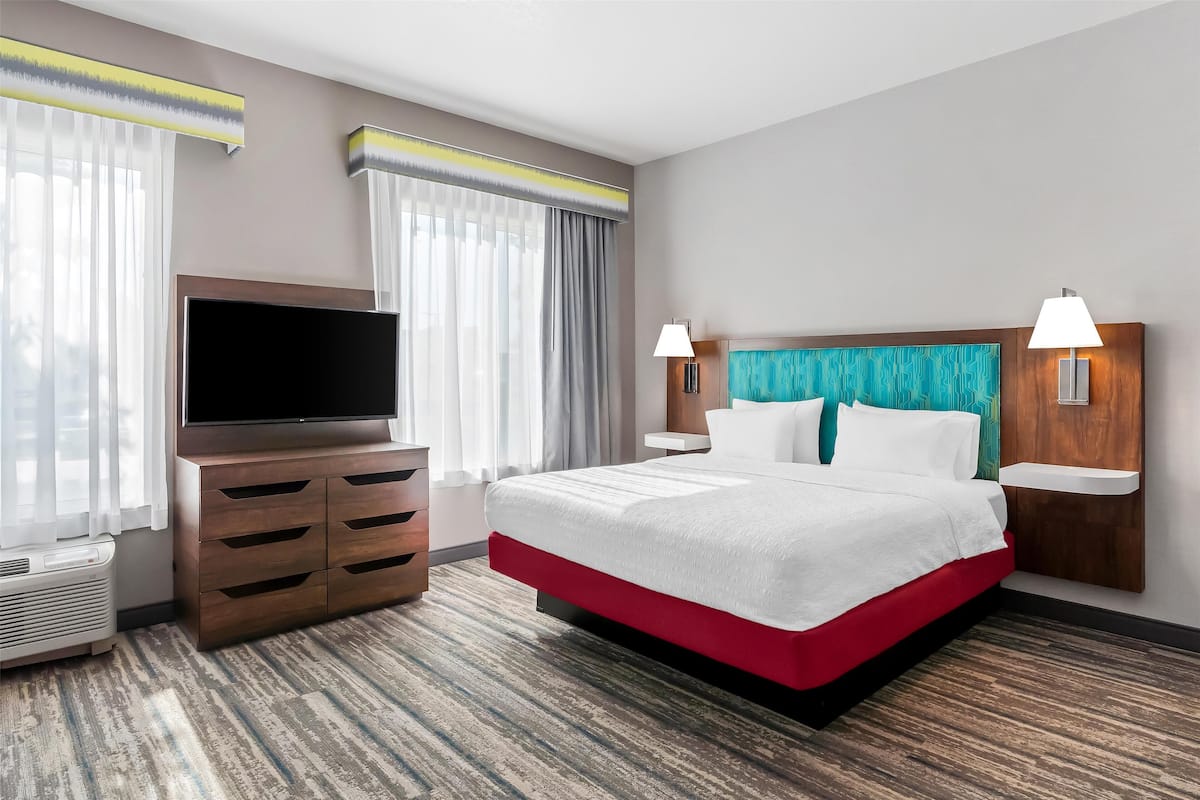 Escritorio, cortinas blackout y tabla de planchar con plancha