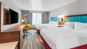 A hotel room with two beds, a desk, a TV, a chair, and a window with curtains. - Hampton Inn & Suites Lathrop (Lathrop)