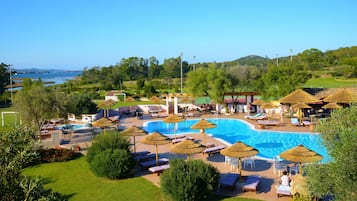 Una piscina al aire libre de temporada, sombrillas