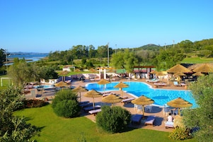Una piscina al aire libre de temporada, sombrillas