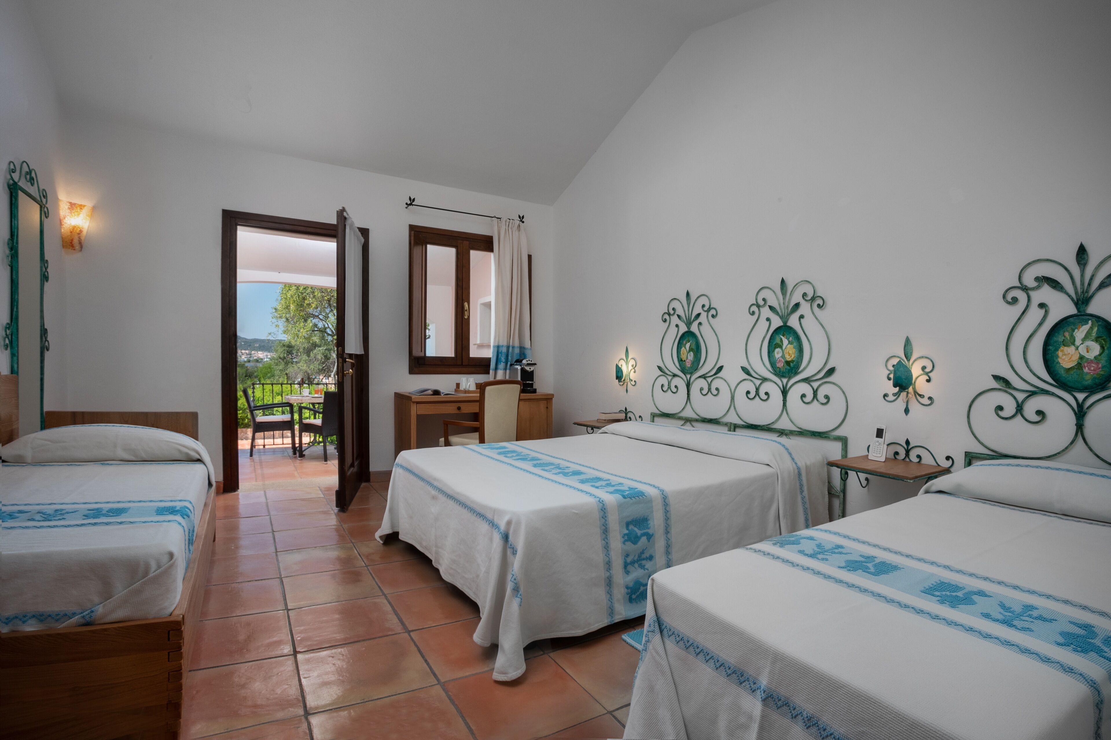 Habitación de hotel con dos camas, un escritorio y vistas al exterior.
