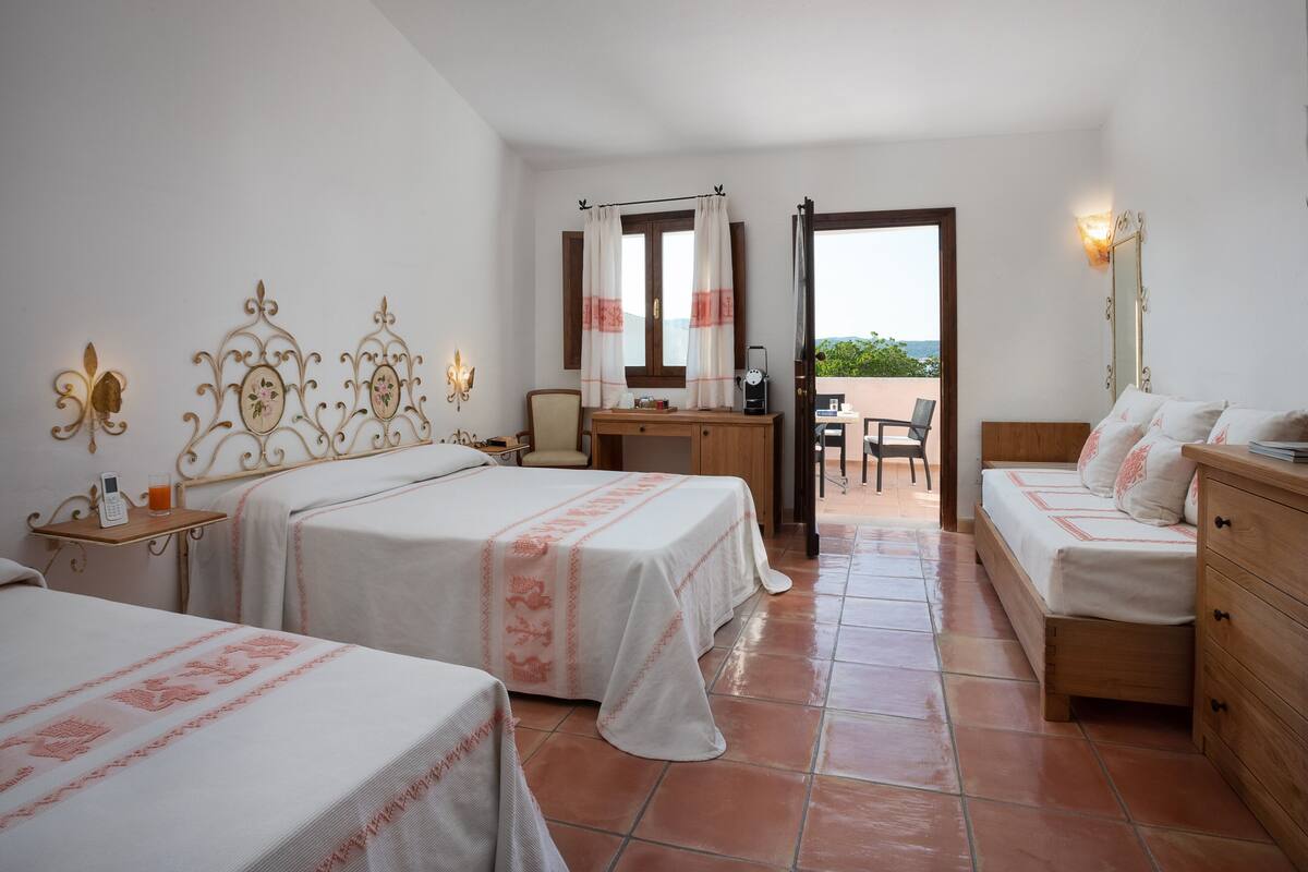 A hotel room with two beds, a desk, and a chair.