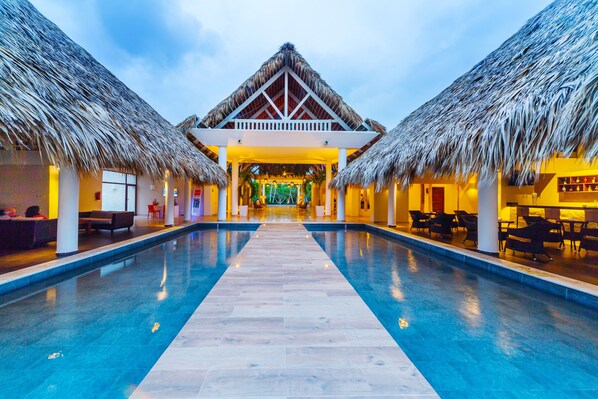 Een buitenzwembad, parasols bij het zwembad en ligstoelen