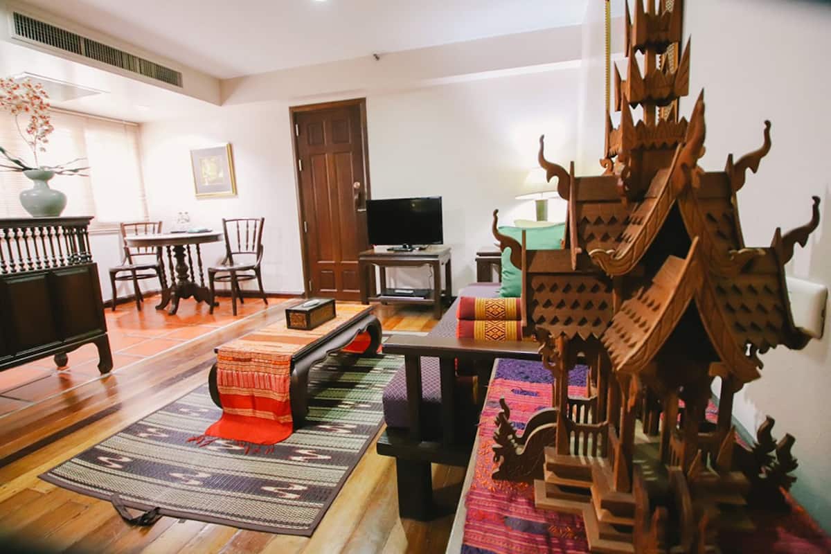Ein Wohnzimmer mit einem Holztisch, Stühlen, einem Fernseher und einer dekorativen Holzkonstruktion.