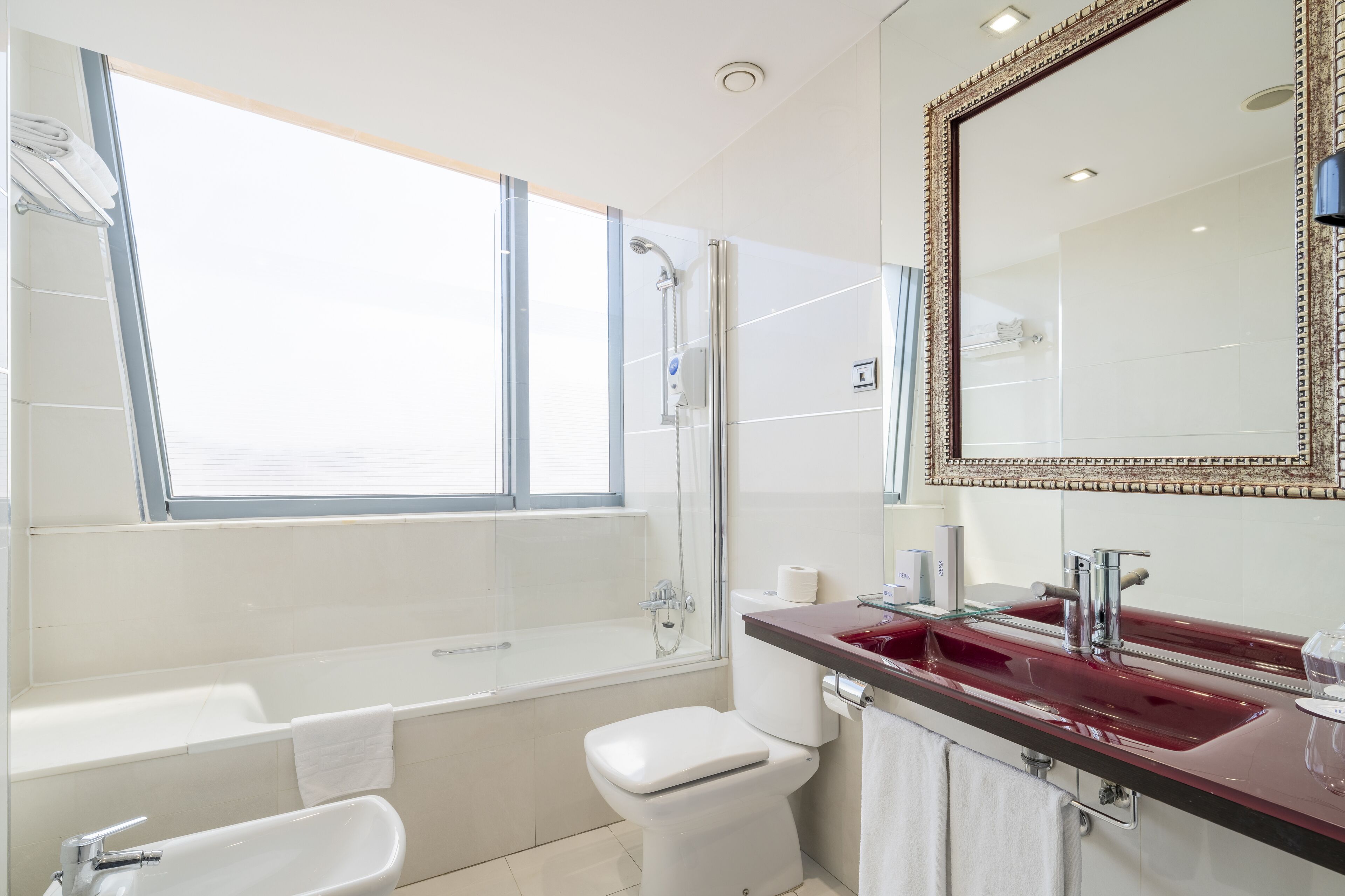 A modern bathroom with a bathtub, shower, toilet, and sink.