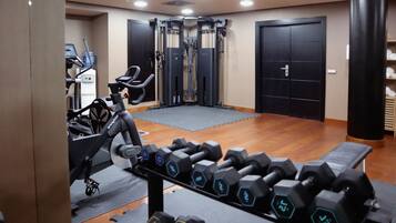 A gym with exercise equipment, a water dispenser, and a treadmill.