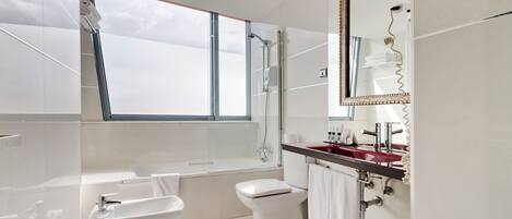 A modern bathroom with a bathtub, a shower, a toilet, and a sink.