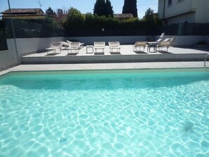 Alberca al aire libre, sombrillas en la alberca y camastros 