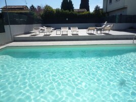 室外游泳池，池畔遮阳伞，日光浴躺椅