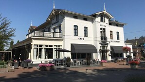Um edifício branco com café, restaurante e hotel.