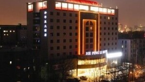 A multi-story hotel with a prominent entrance and illuminated signage. - Beijing Hepingli Hotel (Beijing)