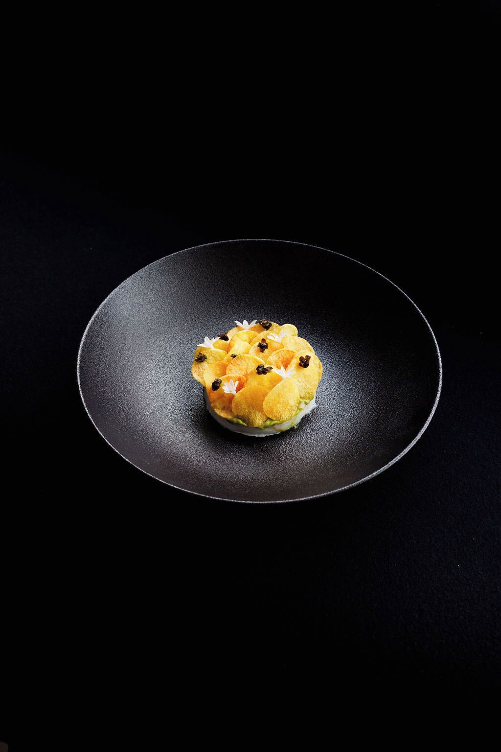 Un plat servi dans une assiette noire.