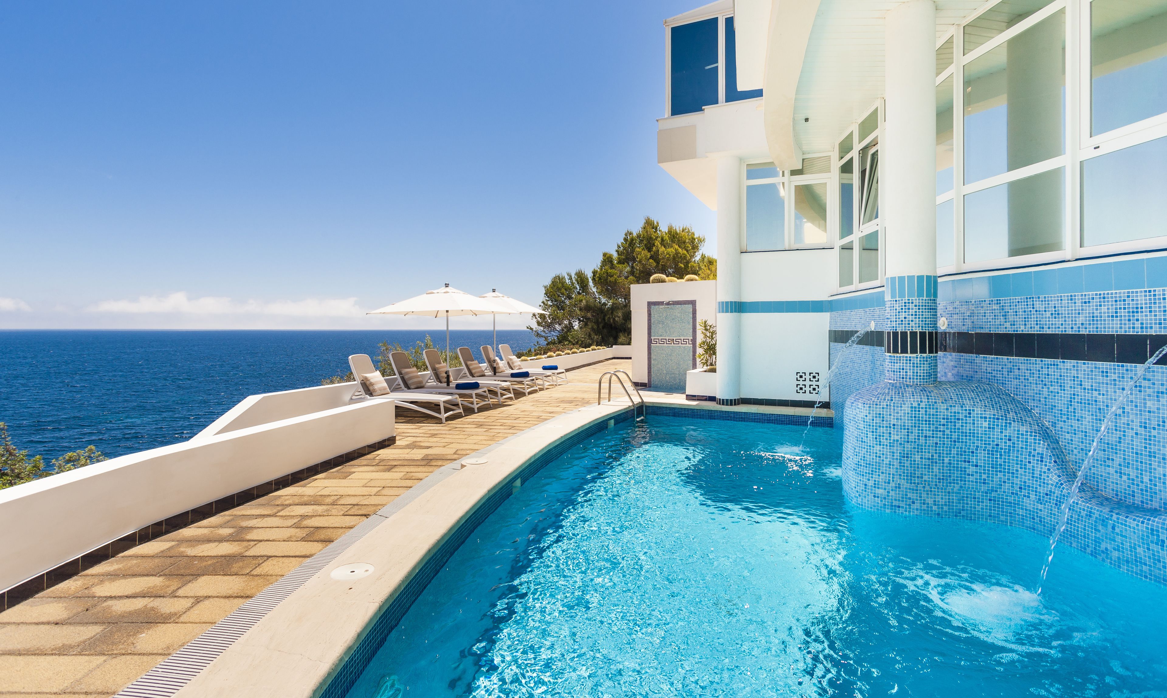 Een binnenzwembad, een buitenzwembad, ligstoelen bij het zwembad