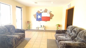 A lobby with two leather sofas, a small table with a flag, and a door. - Hotel Breckenridge (Breckenridge)