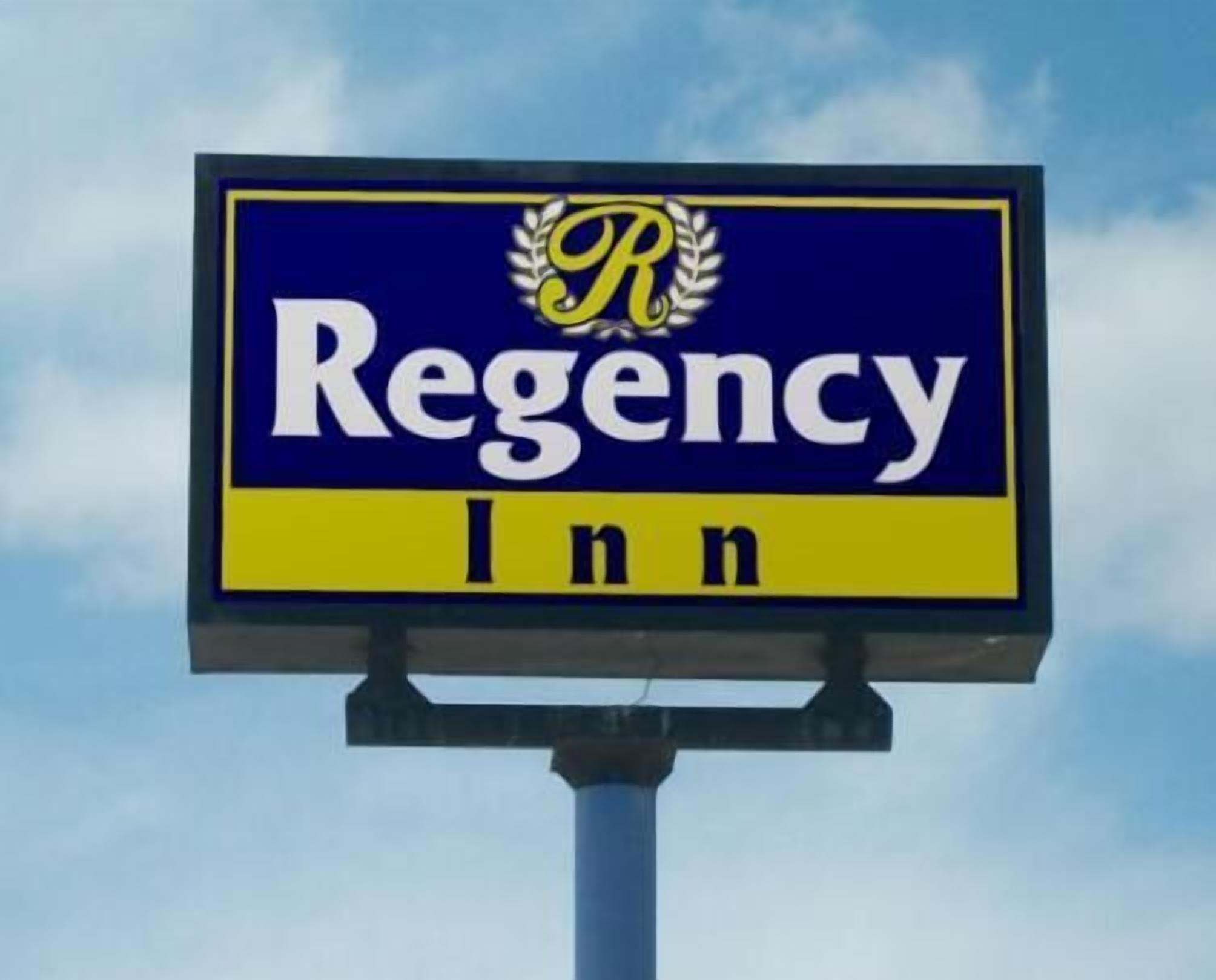 A sign for Regency Inn with a blue background and yellow border.