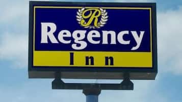 A sign for Regency Inn with a blue background and yellow border.