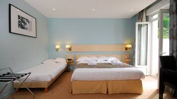 A hotel room with two single beds, a double bed, a piano, and a large window with curtains.