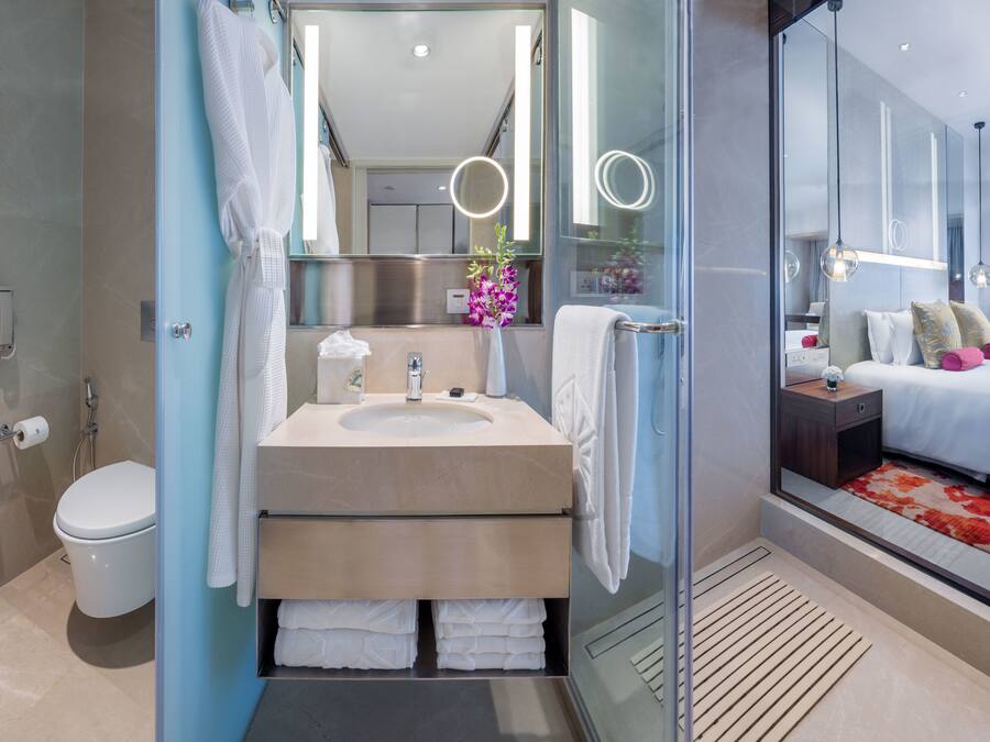A modern bathroom with a glass-enclosed shower, a sink with a towel rack, and a toilet.
