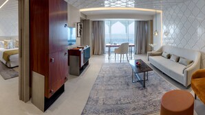 Une chambre d’hôtel moderne avec un canapé, un fauteuil et un coin repas offrant une vue agréable.