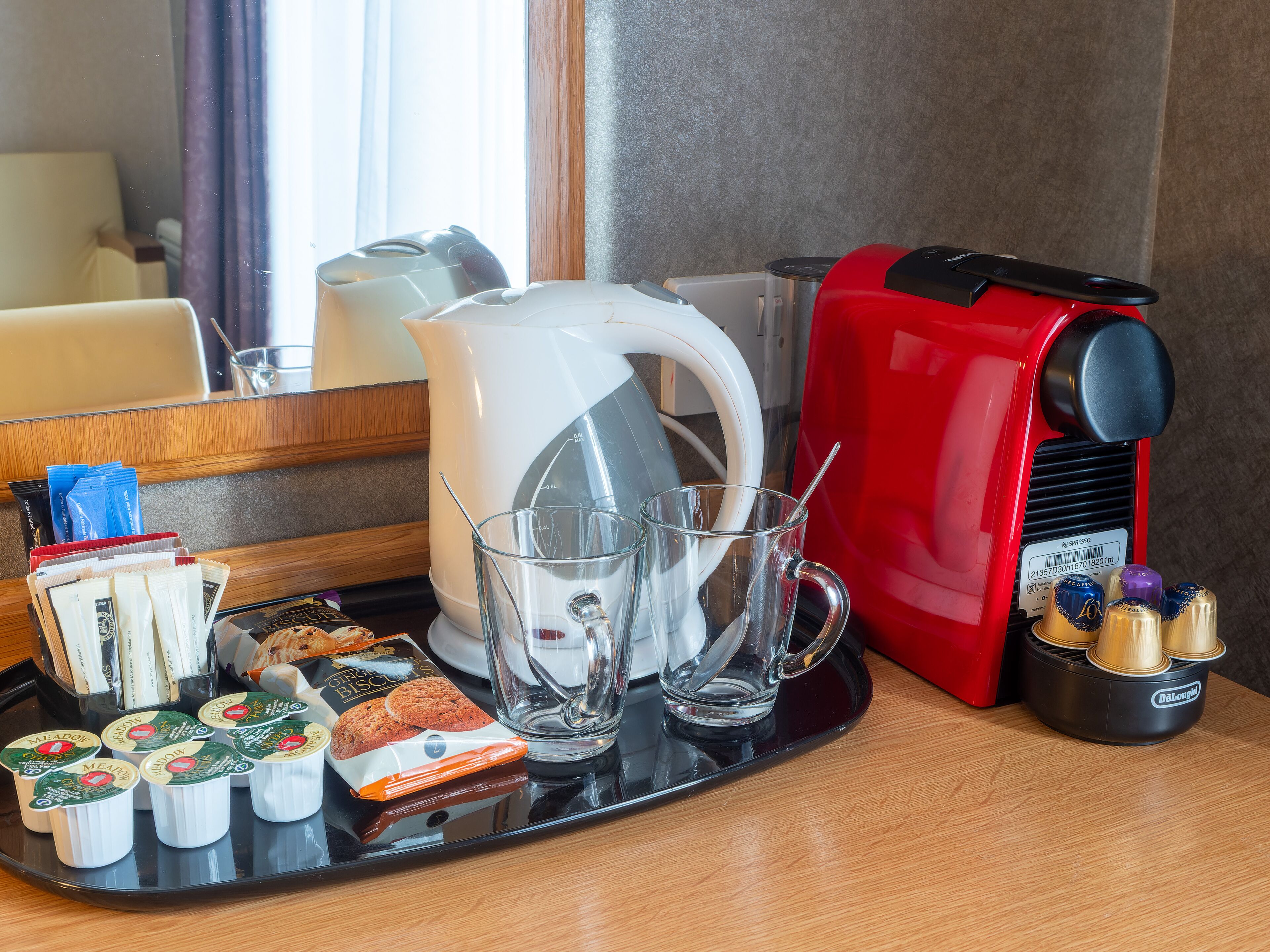 Ein Frühstücksbrett mit Teebeuteln, Keksen und einer Kaffeemaschine.