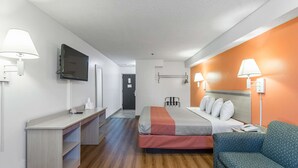 A hotel room with a bed, a sofa, a desk, and a TV. - Motel 6 Lawrence, KS (Lawrence)