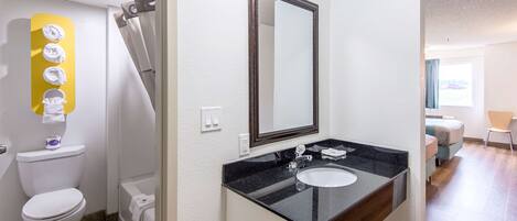 A bathroom with a toilet, sink, and shower.