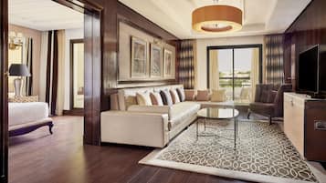 A modern hotel room with a sofa, a TV, a dining table, and a large window offering a city view.