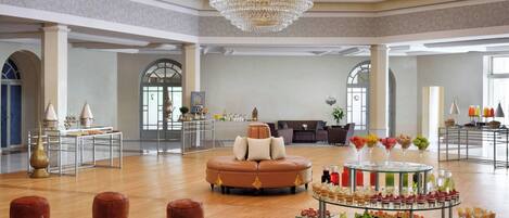 A spacious lobby with a central seating area, a chandelier, and a buffet table.