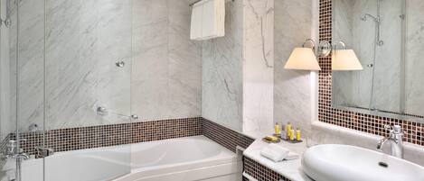 Un baño moderno con una bañera independiente, un espejo grande y un lavamanos con tocador.