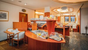 A hotel dining area with a buffet setup, wooden furniture, and a modern interior design.