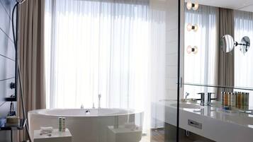 A modern bathroom with a freestanding bathtub, a glass-enclosed shower, and a large mirror.